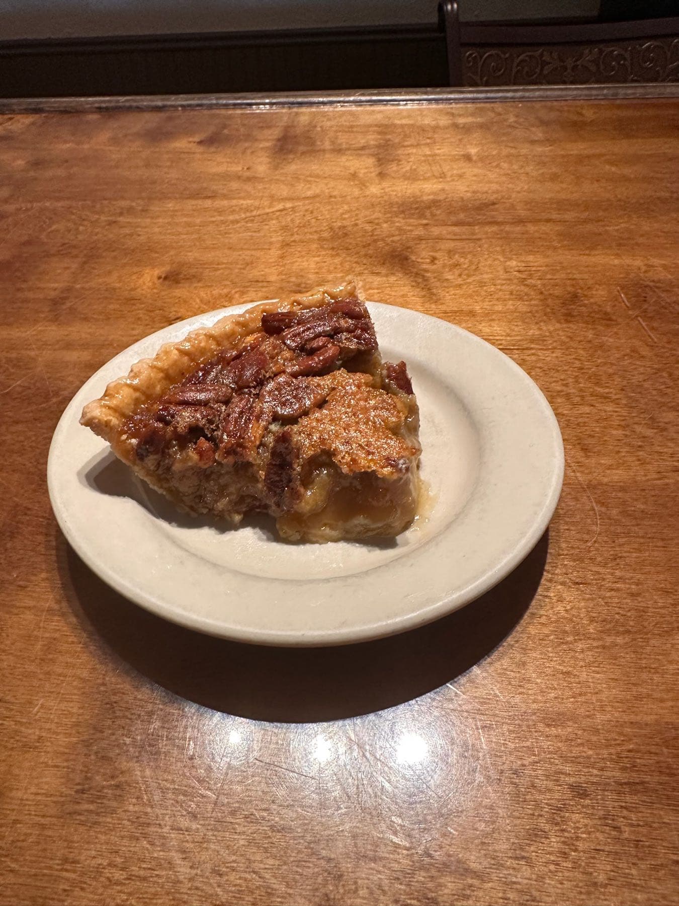 Slice of pecan pie with a flaky golden crust