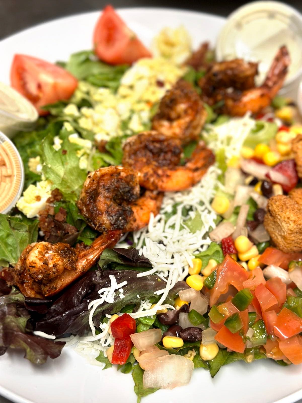 Blackened shrimp cobb salad with mixed greens, shredded cheese, chopped egg, corn and black bean salsa, and diced tomatoes.